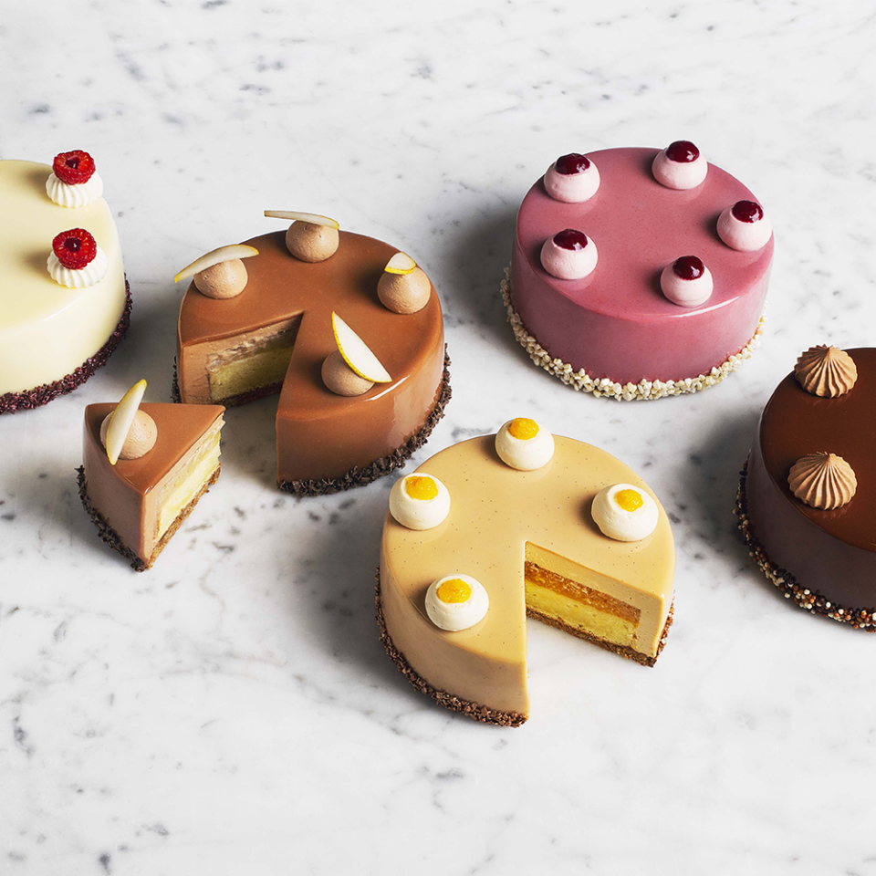 cinco bolos em cima do mármore sendo cada um de uma cor de chocolate: branco, caramelo, ao leite, amargo e ruby